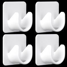 four white toilet paper holders on a black background