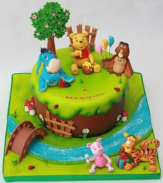 a winnie the pooh birthday cake is decorated with fondant animals and other decorations