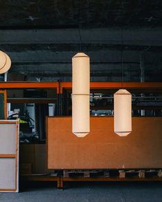 three lamps hanging from the ceiling in a warehouse