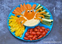 a blue plate topped with vegetables and an orange crab