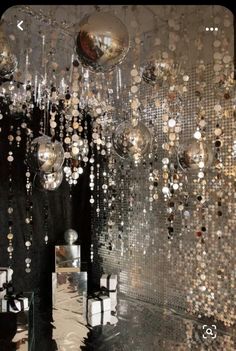 a room filled with lots of shiny balls hanging from it's ceiling and mirrors on the wall