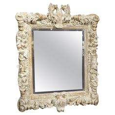 an ornate white framed mirror with birds on it