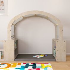 a child's play area with an arch and bookshelf