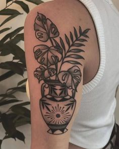 a woman's arm with a vase and flowers on it