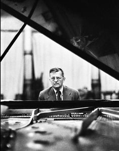 a man sitting at a piano in front of a mirror