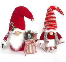 two red and white christmas gnomes sitting next to each other