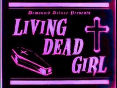 a neon sign that says living dead girl with a cross and book on the front