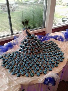 there is a cake made to look like a peacock on top of cupcakes