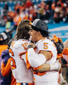 two football players hugging each other on the field