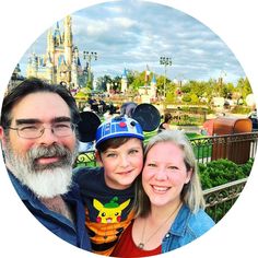 a man and woman pose for a photo in front of mickey mouse's castle