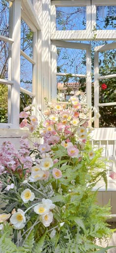 the flowers are blooming in front of the open window on the outside porch,