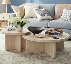 a living room filled with furniture and flowers on top of a table in front of a couch