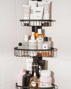 three tiered bathroom shelf filled with cosmetics and personal care products in a white tiled bathroom