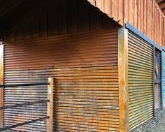 the side of a building with metal slats on it's sides and an open door