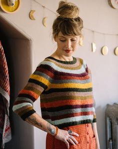 a woman in an orange skirt and striped sweater