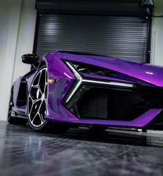 a purple sports car parked in front of a garage door