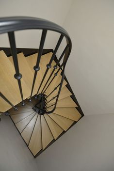 an overhead view of a spiral staircase in a house with white walls and wood flooring