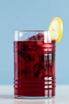 a close up of a drink in a glass with a lemon wedge on the rim