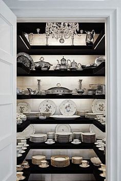 an open pantry filled with lots of plates and bowls