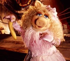 miss piggy is holding a banana in her hand