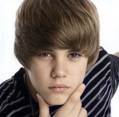 a close up of a person wearing a striped shirt and holding his hand on his chin