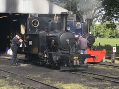 two men standing next to an old fashioned train