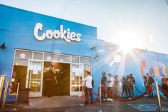 people are lined up in front of a cookie shop