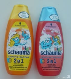 two bottles of shampoo sitting next to each other on a white surface, one is orange and the other is blue