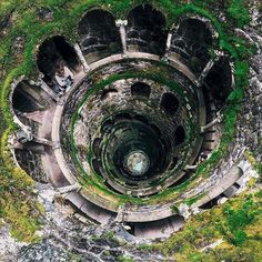 an aerial view of the inside of a stone structure with moss growing on it's sides