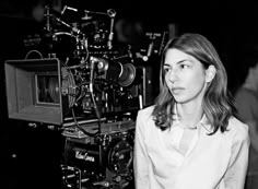 a black and white photo of a woman in front of a camera