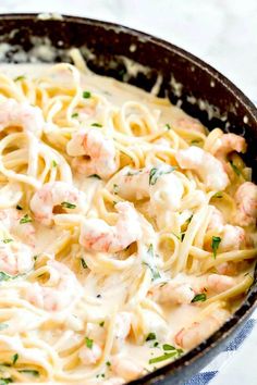 pasta with shrimp and cream sauce in a cast iron skillet