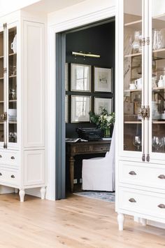 a white china cabinet with glass doors and drawers