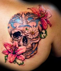 a woman's back with a skull and flowers on it