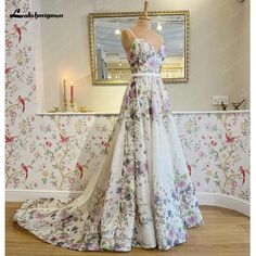 a dress on display in front of a wallpapered room with flowers and candles