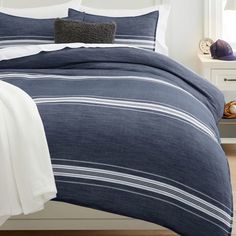 a bed with blue and white striped comforter