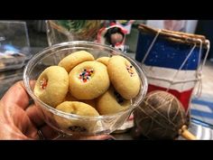 a person holding a glass bowl filled with cookies