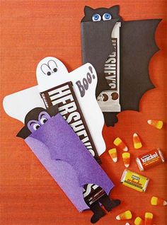 halloween treat bags and candy on a wooden table with bats, bat and tombstones