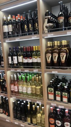 bottles of alcohol are on shelves in a liquor store, with one shelf full of them