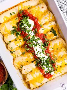 a white casserole dish filled with cheese and sauce, garnished with parsley