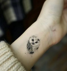 an owl tattoo on the wrist is shown in black and grey ink, while it appears to be painted with watercolors