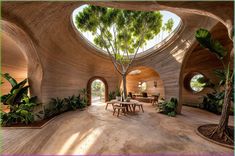 the inside of a house with round windows and plants on either side of the room