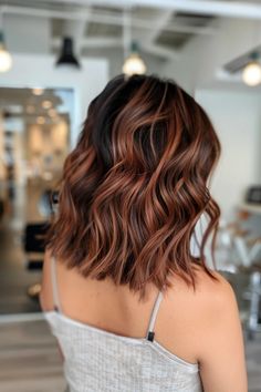 Woman with shoulder-length wavy auburn hair in a modern salon. Short Brown Hair With Red Highlights, Red Lowlights In Brown Hair, Subtle Strawberry Blonde, Copper Lob, Strawberry Brunette, Balayage Brunette Short, Red Highlights In Brown Hair, Copper Balayage Brunette, Brunette Short