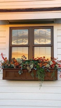 a window box filled with flowers on the side of a house