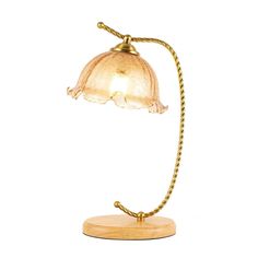 a lamp that is sitting on top of a wooden base and has a glass shade