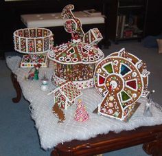 a table topped with lots of decorated gingerbreads on top of a white cloth