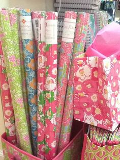 many different colored papers are stacked together in pink baskets on the floor next to each other