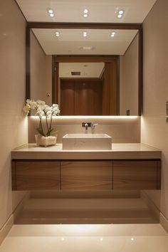 a bathroom with a sink, mirror and flowers in the vase on the counter top