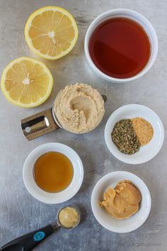 tea, lemons, and other ingredients are arranged in bowls on a gray surface