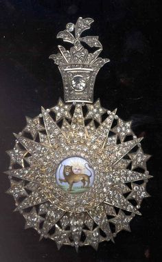 an ornate brooch with a horse on it's center piece, surrounded by diamonds