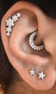 a woman wearing ear piercings with stars on them